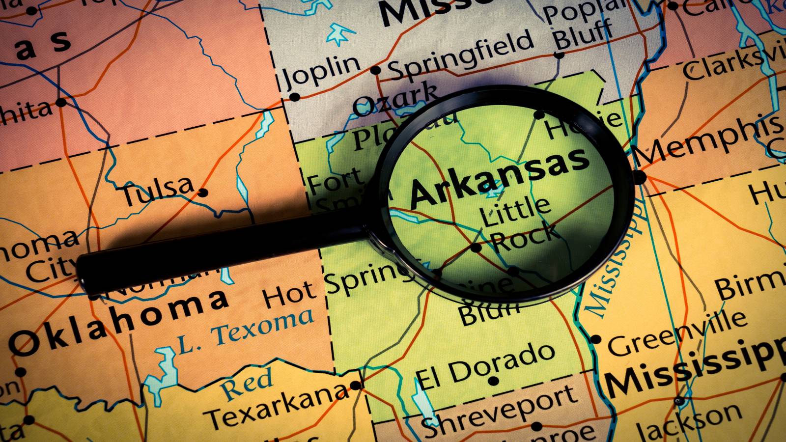 Arkansas on a map underneath a magnifying glass